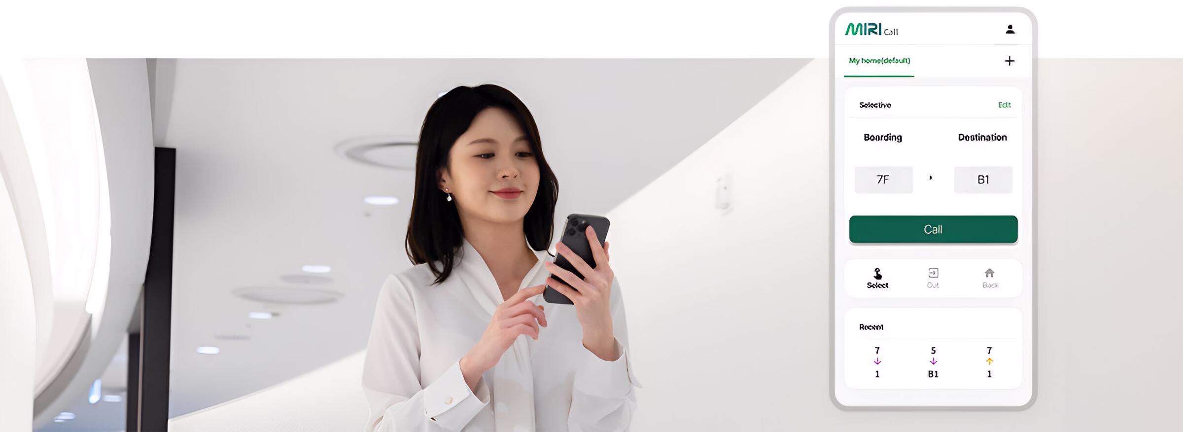 Молода жінка азіатської зовнішності в білій сорочці тримає в руках смартфон і дивиться на нього, на екрані смартфона відображено інтерфейс програми для виклику ліфта з вибраними поверхами 7F як початковий та B1 як кінцевий, праворуч від жінки розміщено збільшене зображення інтерфейсу програми на білому тлі.