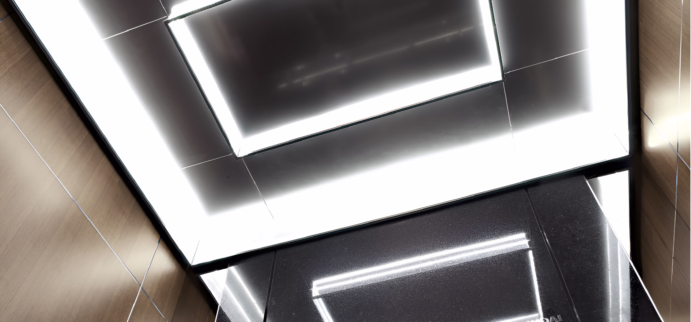 Стеля кабіни ліфта з сучасним дизайном, що включає вбудовані прямокутні світлодіодні світильники на темному тлі.