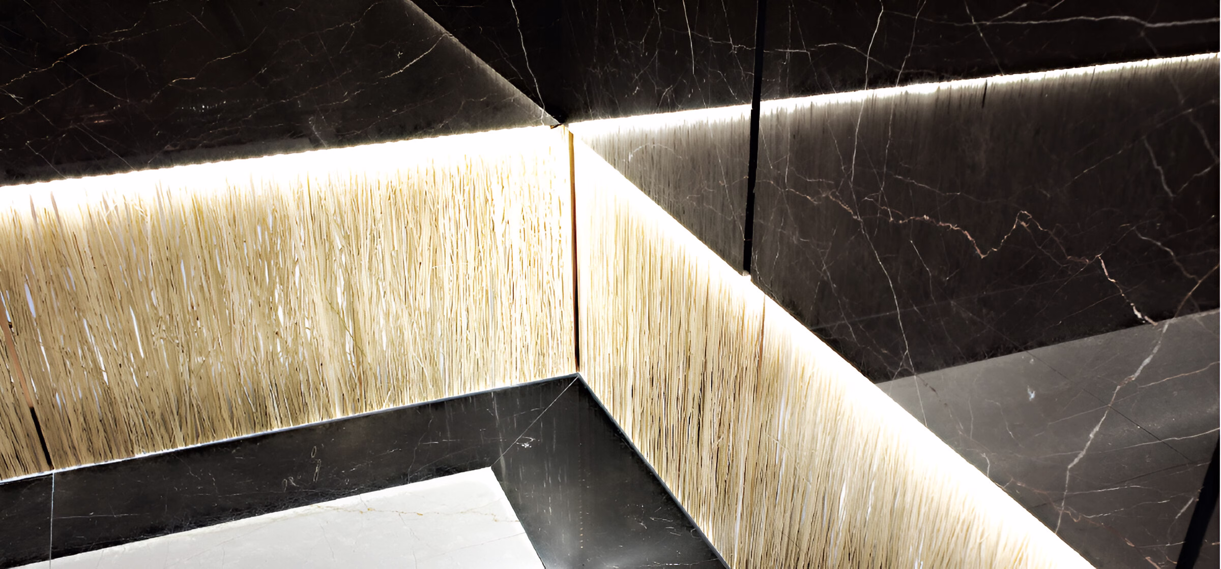 Кут інтер'єру, оздоблений темними мармуровими та світлими текстурованими панелями зі світлодіодною підсвіткою на стиках.