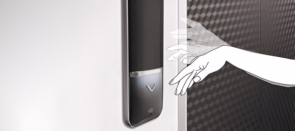 Зображення руки, що наближається до сенсорної панелі на ліфтових дверях, ілюструючи безконтактне керування ліфтом.